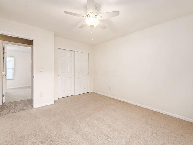 unfurnished bedroom with carpet floors, a closet, and ceiling fan