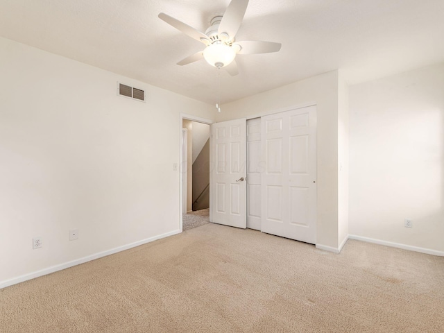 unfurnished bedroom with light carpet, a closet, and ceiling fan