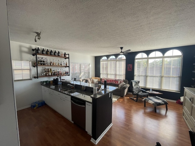 kitchen with a textured ceiling, white cabinetry, dishwasher, and dark hardwood / wood-style floors