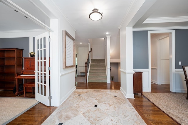 foyer entrance with decorative columns, crown molding, and hardwood / wood-style floors