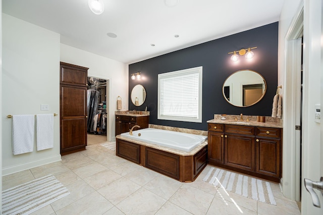 bathroom featuring tile patterned floors, vanity, and a bath