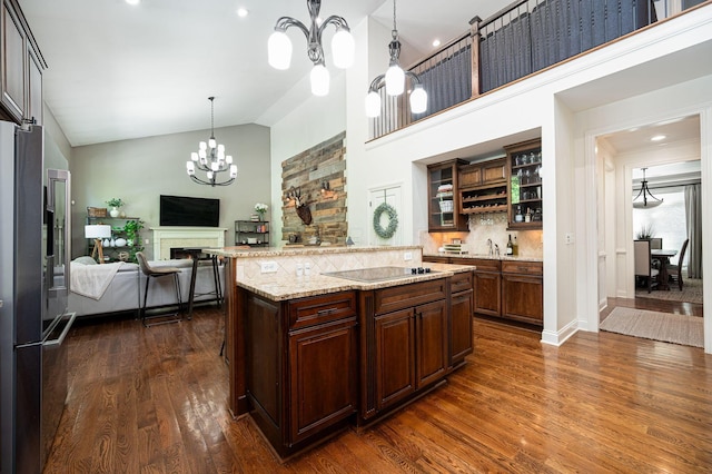 kitchen with dark hardwood / wood-style flooring, high quality fridge, black electric cooktop, high vaulted ceiling, and a center island