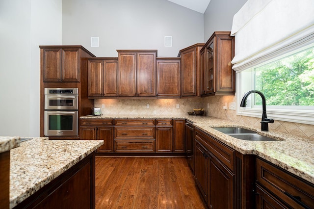 kitchen featuring appliances with stainless steel finishes, backsplash, lofted ceiling, and sink