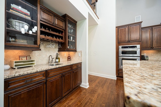 kitchen featuring backsplash, dark wood-type flooring, and sink