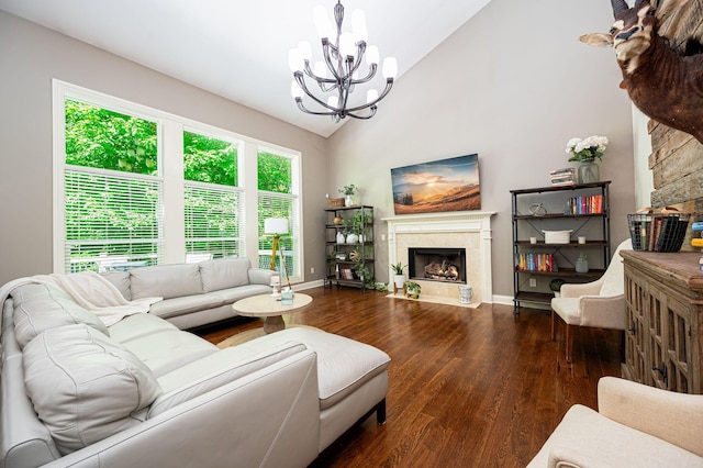 living room with hardwood / wood-style floors, a fireplace, high vaulted ceiling, and an inviting chandelier