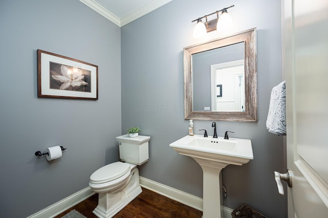 bathroom featuring wood-type flooring, toilet, ornamental molding, and sink