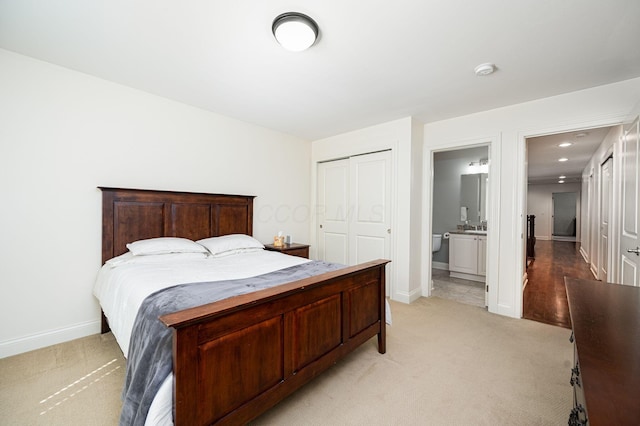 carpeted bedroom featuring ensuite bath and a closet