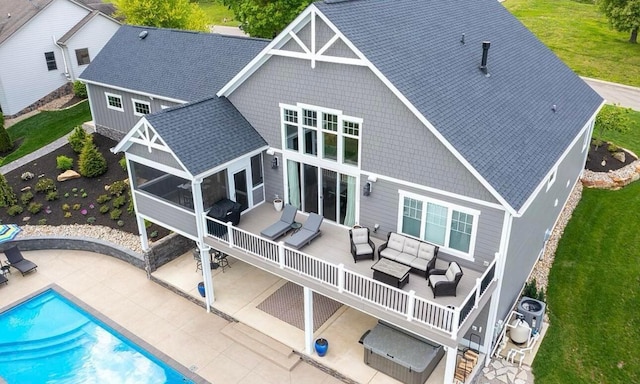 rear view of property with a patio area, an outdoor living space, and a yard