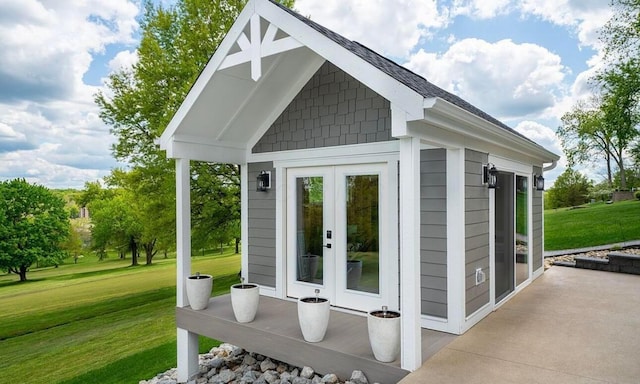 view of outdoor structure featuring a lawn and french doors