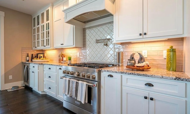 kitchen with tasteful backsplash, white cabinetry, high end stainless steel range, and custom exhaust hood