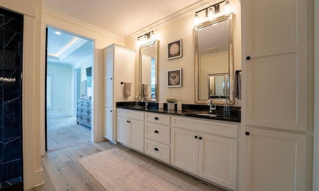 bathroom featuring hardwood / wood-style floors, vanity, and crown molding