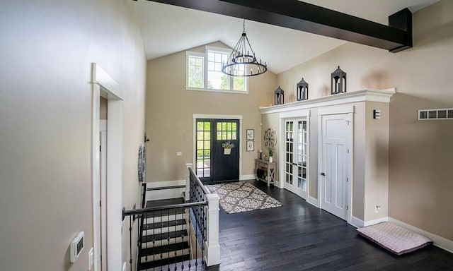 foyer entrance with dark hardwood / wood-style flooring, high vaulted ceiling, french doors, and a notable chandelier