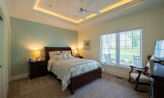 carpeted bedroom featuring a raised ceiling, ceiling fan, and crown molding