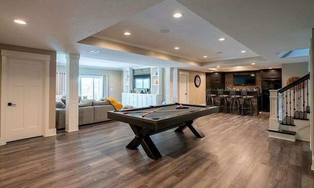 playroom featuring a raised ceiling, bar, hardwood / wood-style floors, and pool table