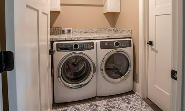 laundry area with washer and clothes dryer and cabinets