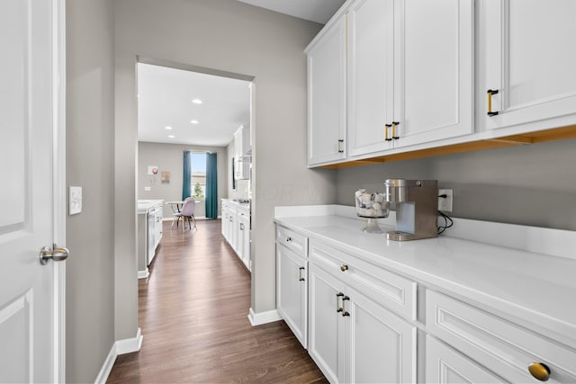 bar featuring white cabinets and dark hardwood / wood-style floors