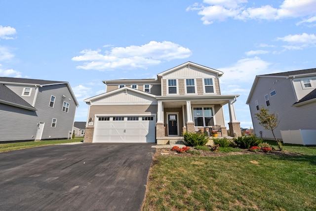 view of front of home featuring a garage, covered porch, and a front lawn