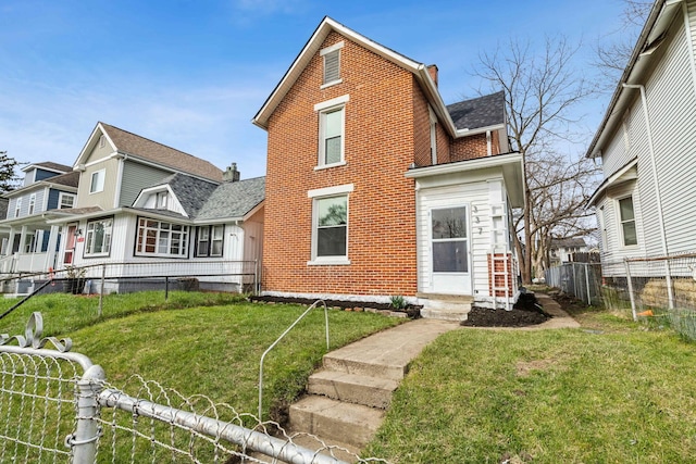 rear view of house featuring a lawn