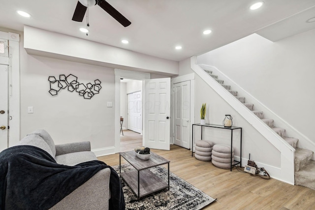 living room with ceiling fan and light hardwood / wood-style flooring