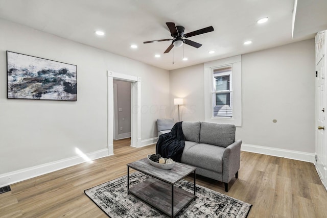 living room featuring light hardwood / wood-style flooring and ceiling fan