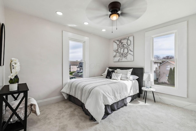 carpeted bedroom with multiple windows and ceiling fan