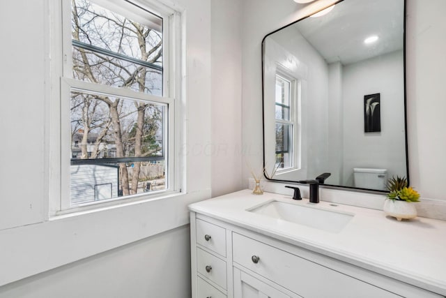 bathroom with vanity, toilet, and a wealth of natural light