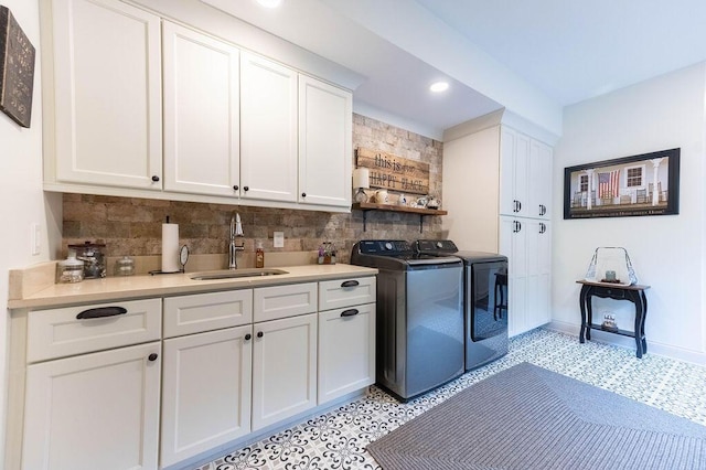 laundry area featuring cabinets, washer and dryer, and sink