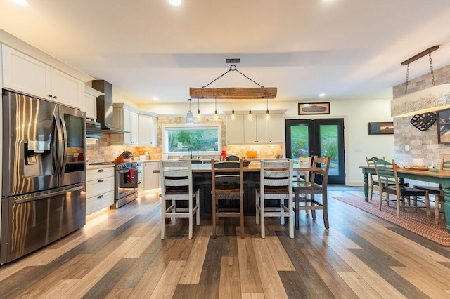 dining space with french doors, sink, and light hardwood / wood-style flooring