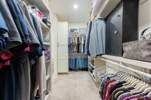 walk in closet featuring light carpet