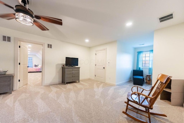 sitting room featuring ceiling fan and light carpet