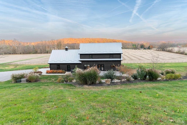 exterior space featuring a lawn and a rural view