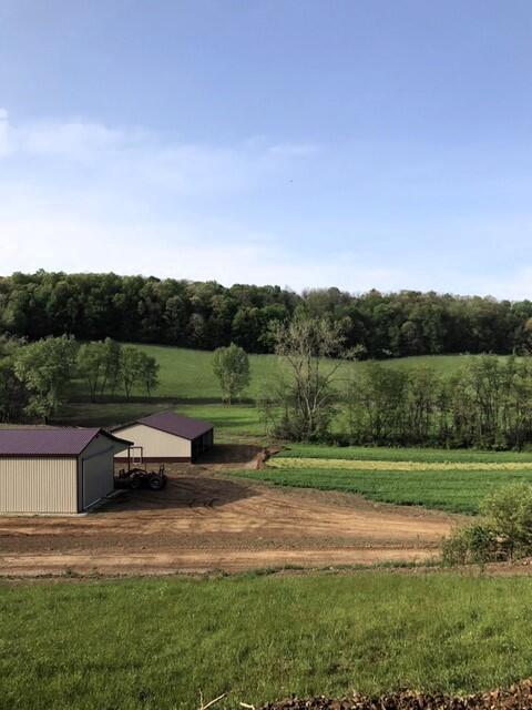 view of community with a rural view, an outdoor structure, and a lawn