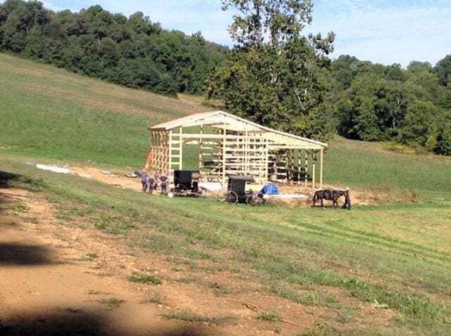 view of outdoor structure featuring a rural view and a lawn