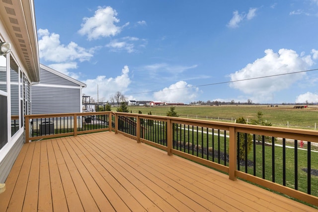 wooden deck featuring a rural view and a lawn