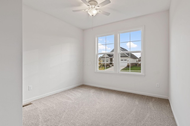 carpeted spare room featuring ceiling fan