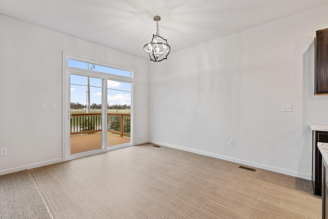 unfurnished dining area featuring a notable chandelier