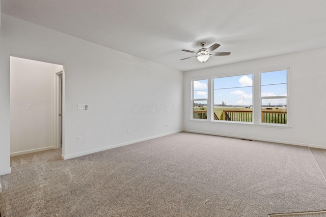 carpeted spare room with ceiling fan