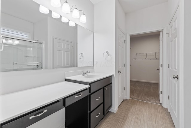 bathroom with a shower with door and vanity