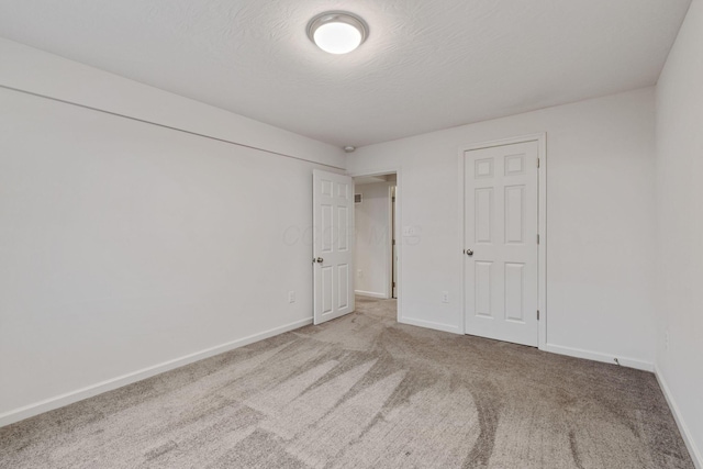 unfurnished bedroom with light carpet and a textured ceiling