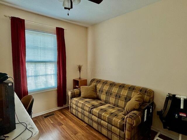 living room with hardwood / wood-style floors and ceiling fan