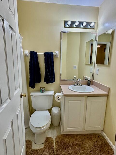 bathroom featuring tile patterned floors, vanity, and toilet