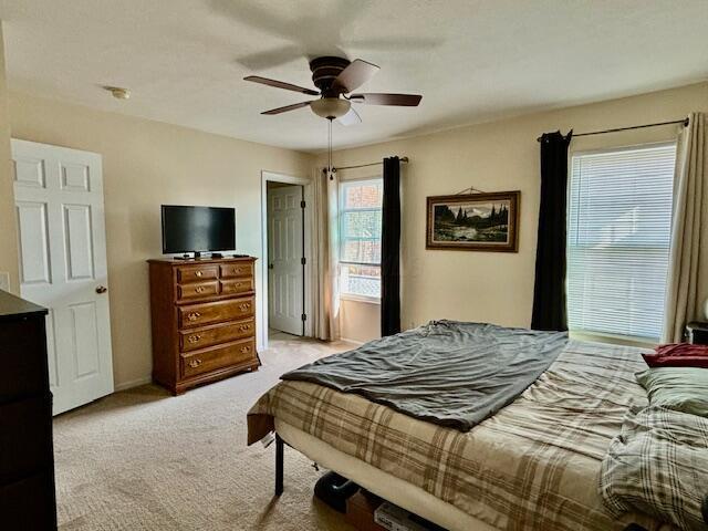 bedroom featuring light carpet and ceiling fan