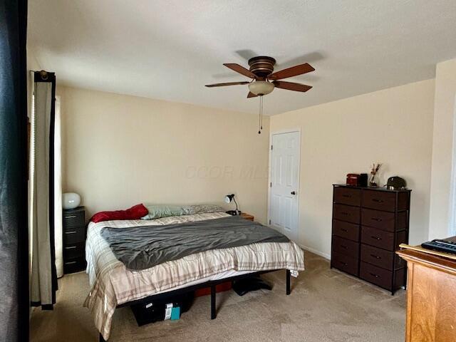 bedroom with ceiling fan and light carpet