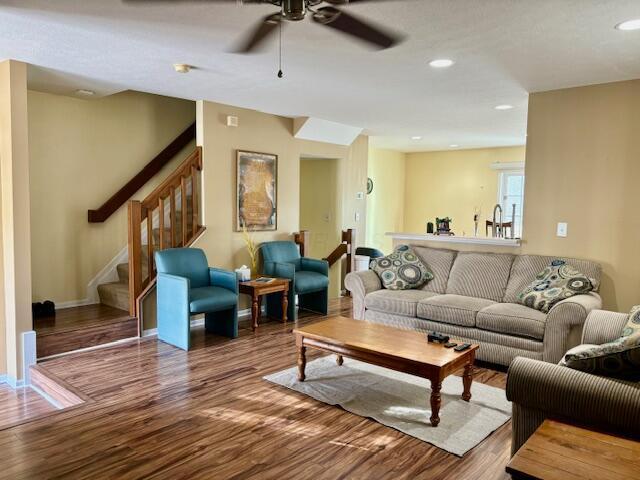 living room with ceiling fan, sink, and wood-type flooring