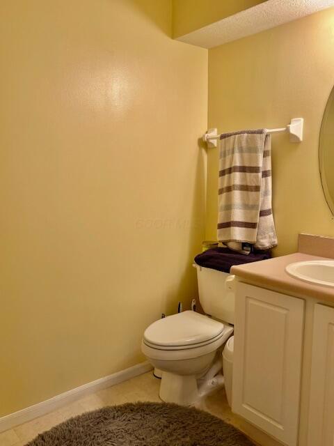 bathroom with tile patterned flooring, vanity, and toilet