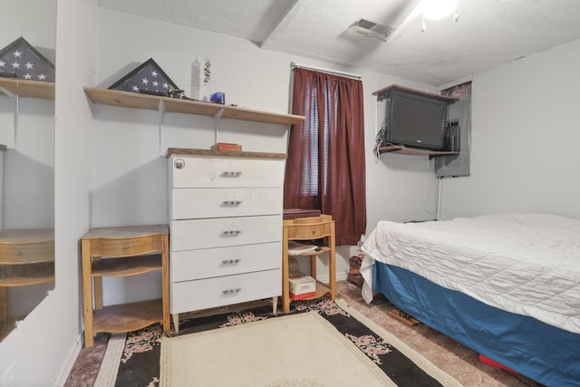 carpeted bedroom featuring ceiling fan and a textured ceiling