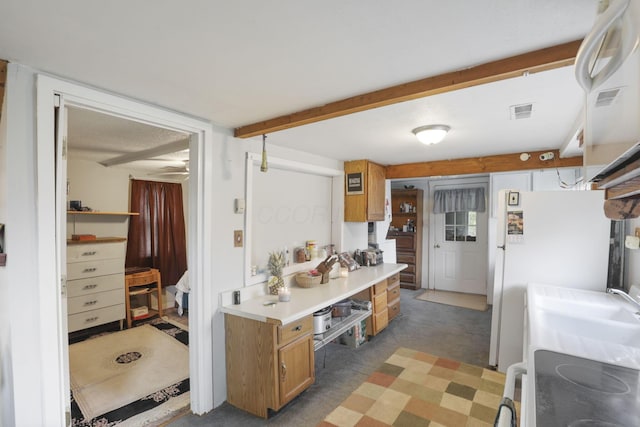 kitchen featuring sink, white fridge, and range