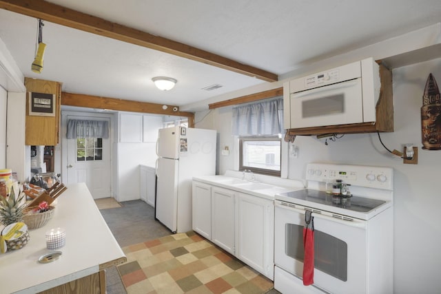 kitchen with white cabinets, plenty of natural light, white appliances, and sink