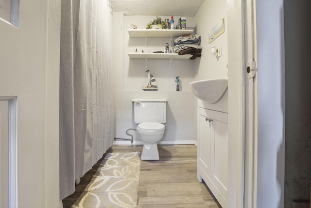 bathroom featuring hardwood / wood-style floors, vanity, a textured ceiling, and toilet