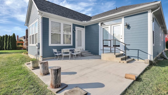 back of property featuring a lawn and a patio